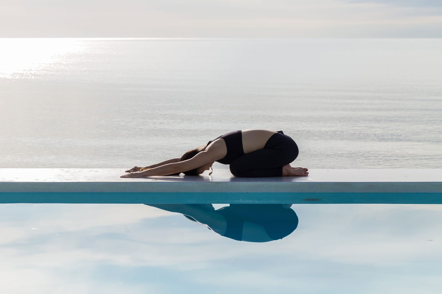 Woman in Child's Pose on a yoga mat.