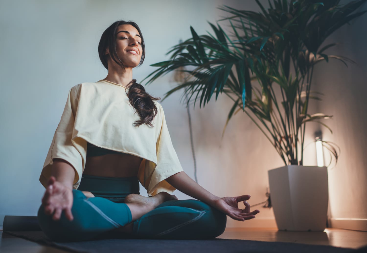Woman practising yoga outdoors at sunrise.